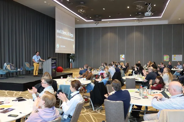 A full room at the Org Design Summit 2026 applauding a talk